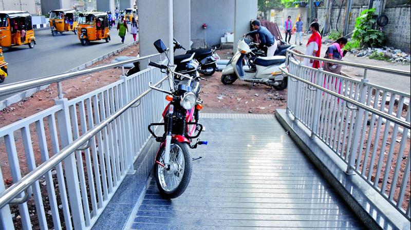 Vehicles are seen parked on the ramp of a Metro station and a few others are parked right infront of the ramp due to lack of parking spaces from LB Nagar to Ameerpet stretch. (Image: Deepak Deshpande)
