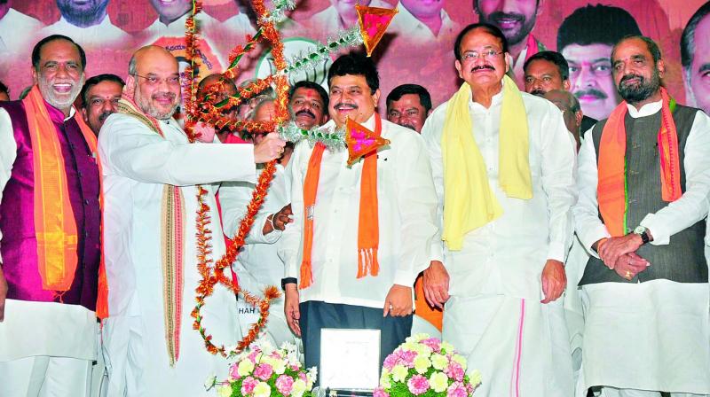 BJP national president Amit Shah takes aim as Union minister Venkaiah Naidu, MLC Ramachandra Reddy, TS BJP president K. Laxman and others look on, at a function hall in Hyderabad on Wednesday. 	(Photo: DC)