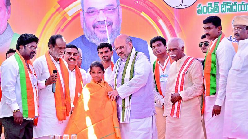 BJP national president Amit Shah felicitates Banda Geethika, a Class VII girl and an expert in yoga on Wednesday. Geethika had earlier done yoga along with Prime Minister Narendra Modi. She is native of Gundrampally village of Chityala mandal in Nalgonda district. She has participated in national-level yoga events and would visit New Delhi next month to do yoga with the PM again. (Photo: DC)