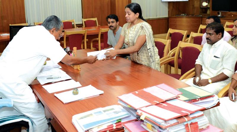 Jishnus mother Mahija hands over a memorandum after meeting the Chief Minister.