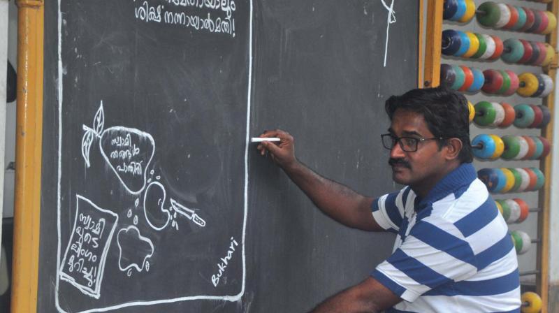 Bukhari busy drawing cartoons on the entrance of his house at Peruvallur in Tirurangadi.