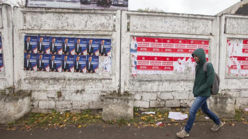 In this picture taken Wednesday, Oct. 26, 2016, a woman walks by electoral posters in Chisinau, Moldova. (Photo: AP)