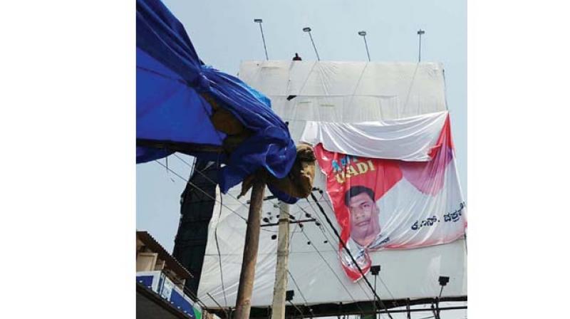 A file picture of hoardings being removed by BBMP workers, at Kempegowda Airport road in Bengaluru   	(Photos: KPN)