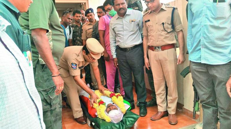 Bhadradri-Kothagudem district SP Amber Kishore Jha pays tribute to the slain cop Susheel Kumar in Bhadrachalam on Friday.