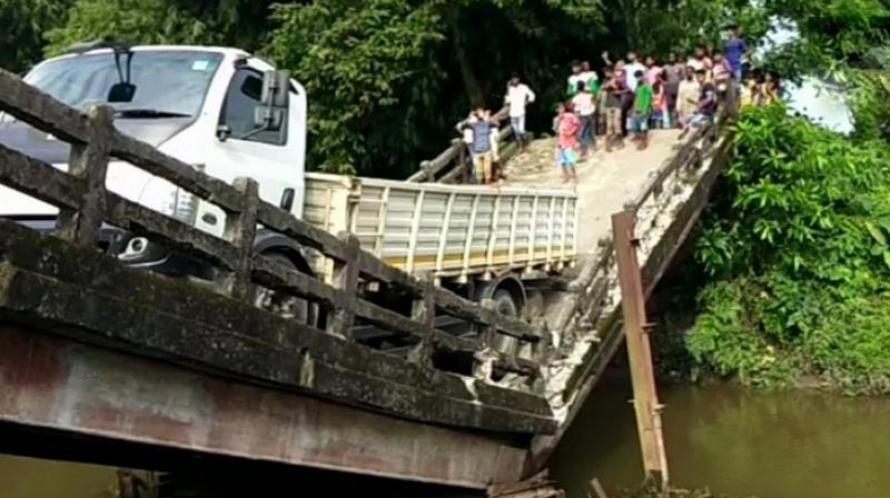 The truck is still hanging from the broken portion of the bridge that connects Manganj area to Siliguri, a major city in north Bengal. (Photo: Twitter | ANI)
