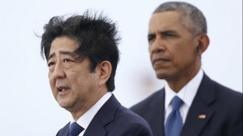 Japanese Prime Minister Shinzo Abe, left, joined by President Barack Obama, speaks on Kilo Pier overlooking the USS Arizona Memorial, part of the World War II Valor in the Pacific National Monument, in Joint Base Pearl Harbor-Hickam, Hawaii