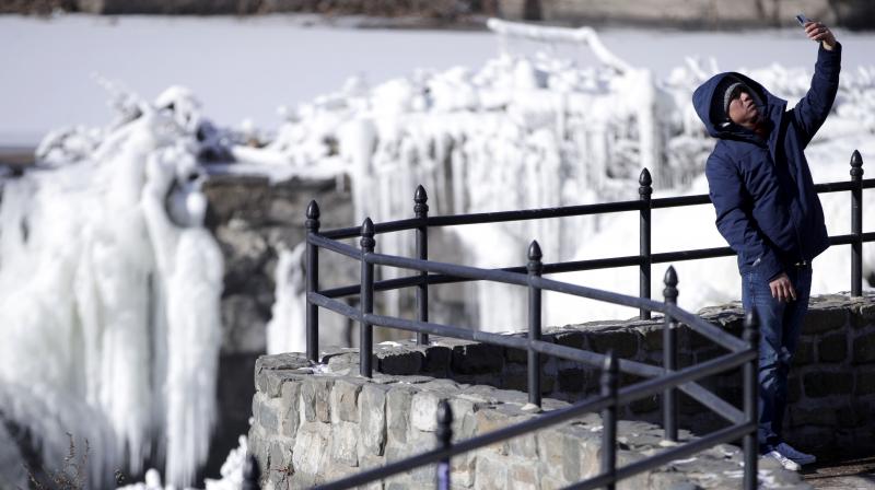 Obdulio Arenas, of Paterson, N.J., uses a cell phone to capture a selfie in front of the partially frozen falls at the Paterson Great Falls National Historical Park, Tuesday, Jan. 2, 2018, in Paterson, N.J. (Photo: AP)