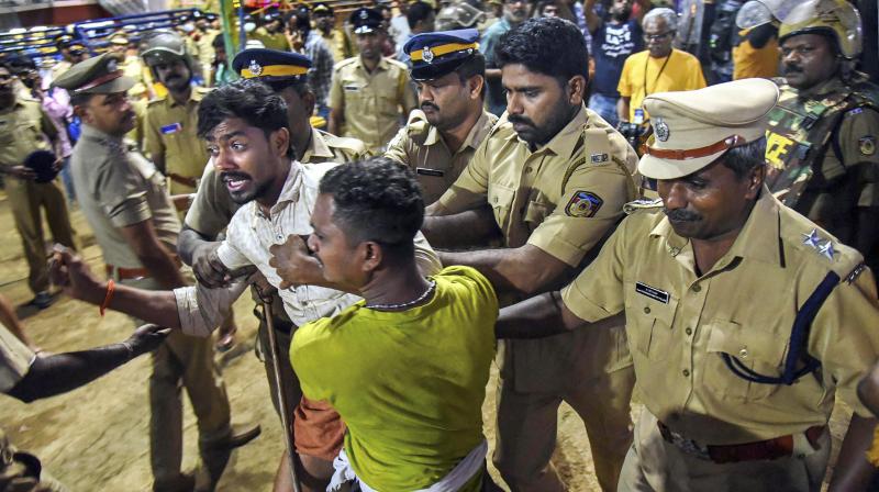 Police personnel detain the devotees who were staging Namajapa protest against the police restrictions at Sannidhanam, in Sabarimala on Sunday. (Photo: PTI)