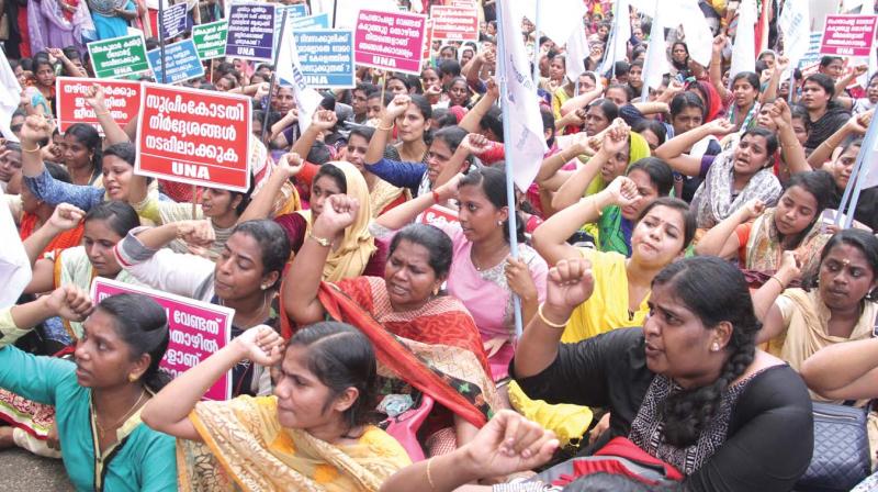 Members of United Nurses Association (UNA) hold a sit-in protest in front of Thrissur Collectorate on Monday.