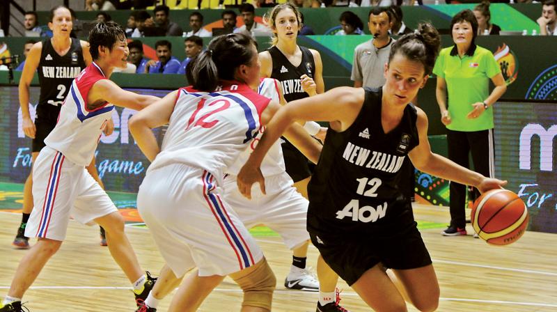 Jillian Harmon of New Zealand tries to get past DPR Koreas  Suk Yong Ro during their match on Monday.	(Photo: R. Samuel)