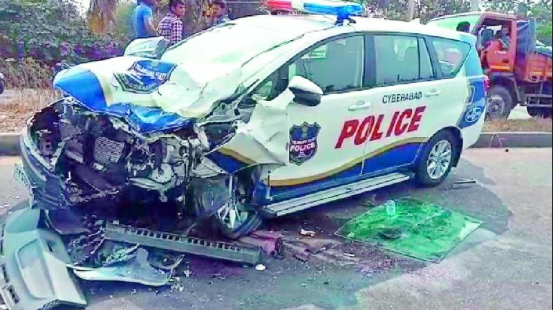 The damaged police patrol car lies in the middle of the road after the accident.