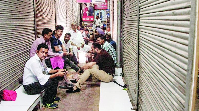 Cloth market traders sit outside their closed shops during a protest on the fourth day of the new GST regime at Chandni Chowk Market in New Delhi on Tuesday. (Photo: AP)