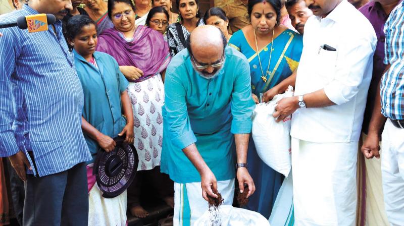 Finance Minister T.M. Thomas Isaac adds innoculum to a kitchen bin at a house at Sasthamangalam as part of zero-waste campaign on saturday. (Photo: A.V. MUZAFAR)