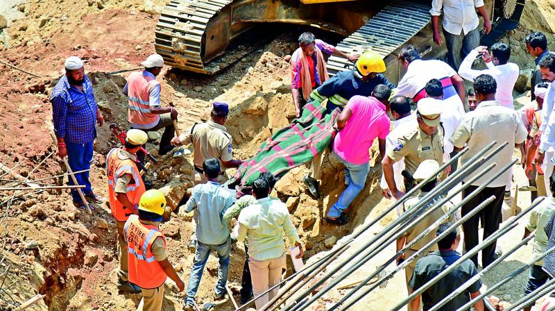 The extricated body of one of the two women workers being shifted to higher ground. The two workers died when the retaining wall of a cellar under construction caved in at Kondapur on Monday. (Photo: DC)