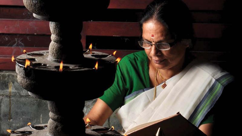 A woman reads the Ramayana at home during Karkidakam. (file pic)