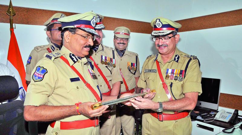 Outgoing DGP Anurag Sharma hands over the baton to M. Mahendar Reddy who assumed charge in Hyderabad on Sunday. (Photo: DC)