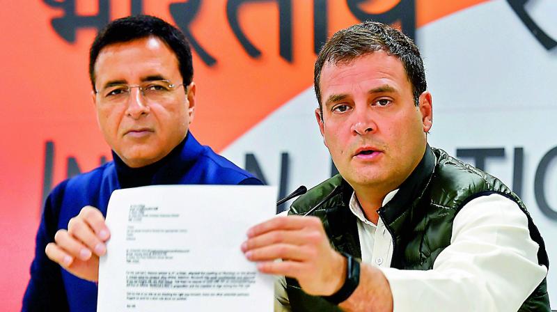Congress president Rahul Gandhi addresses press conference at AICC office, Tuesday. Party  spokesperson Randeep Surjewala is also seen. (Photo: AP)
