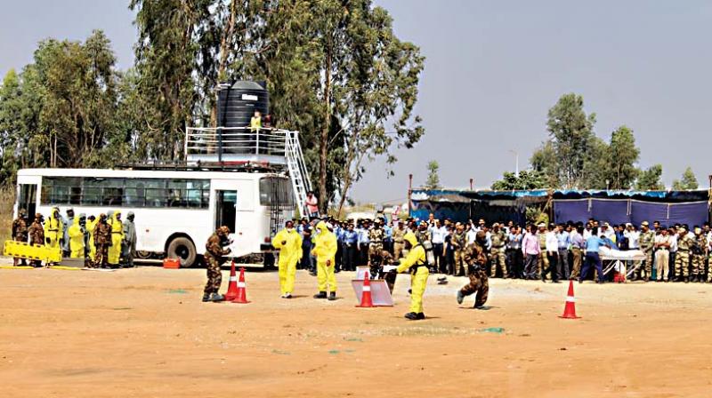 Members of National Disaster Response Force perform during a mock drill to deal with gas leak outside the Kempegowda International Airport in Bengaluru on Saturday (Photo: DC)