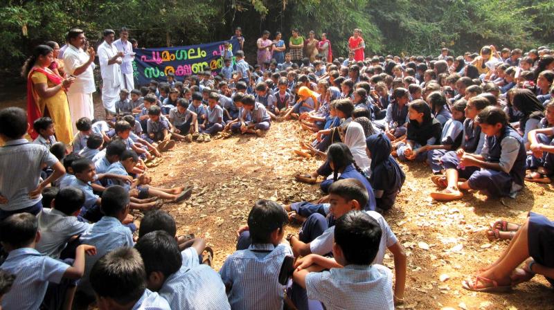 Students of Poomangalam AUPS form a human chain for the protection of Poomangalam river. 	DC FILE