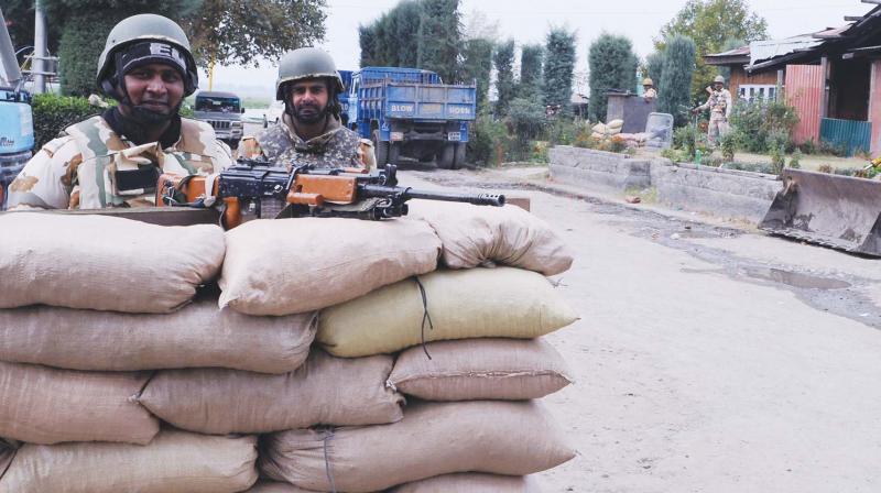 Security force personnel stand guard behind a newly-built sandbag bunker in Srinagar (Photo: H.U.Naqash)