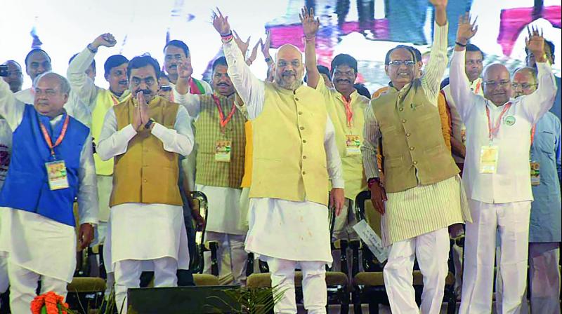 Asaduddin OwaisiBJP president Amit Shah and Madhya Pradesh Chief Minister Shivraj Singh Chouhan wave at the crowd during Jan Ashirwad Yatra, in Ujjain, on Saturday. (Photo: PTI)