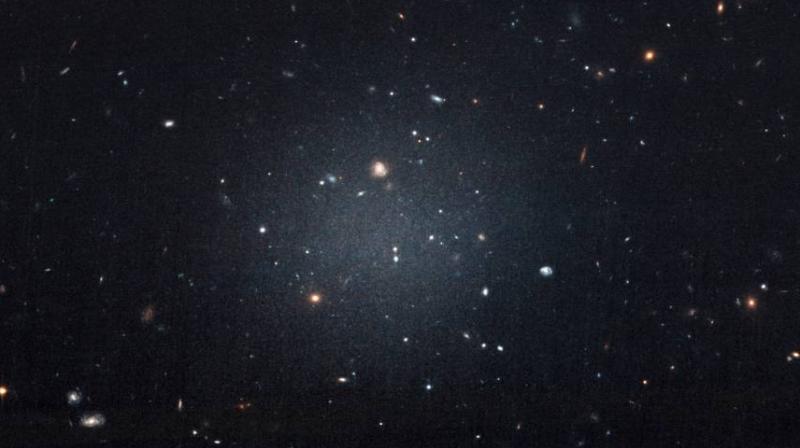 This Nov. 16image made with the Hubble Space Telescope shows the diffuse galaxy NGC 1052-DF2, lighter area in center. Several other galaxies can be seen through it. The unusual galaxys stars are speeding around with no apparent influence from dark matter, according to a study published on Wednesday in the journal Nature. (Photo: AP)
