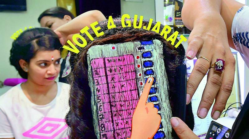 A girl with an EVM painted on her hair campaigns for voting ahead of Gujarat Assembly polls, in Ahmedabad on Thursday. (Photo:  PTI)