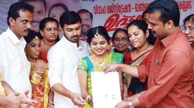 Mayor V.K. Prashanth presents marriage certificates to couples inaugurating the online marriage registration kiosk initiative at the main office. Deputy Mayor Rakhi Ravikumar and standing committee chairpersons are also seen. 	 DC