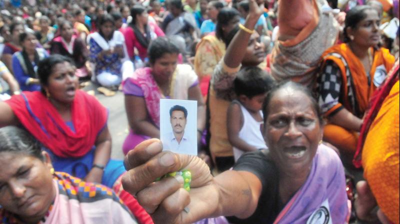 Flori from Valiyathura shows picture of her nephew Jose who has gone missing in the sea following Ockhi, during a Raj Bhavan march on Monday. (Photo: A.V. MUZAFAR)