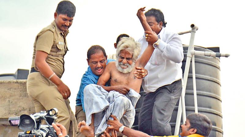 Cops bring down activist Traffic Ramaswamy, who threatened suicide, from atop a building in the city on Saturday. (Photo: DC)