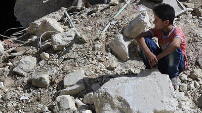 A boy sits amongst rubble in rebel-held eastern Aleppo, Syria. (Photo: AP)