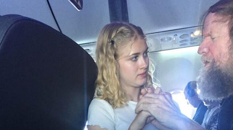Clara Daly helping out th eblind and deaf man on an Alaska Airlines flight. (Facebook Screengrab/ Lynette Scribner)