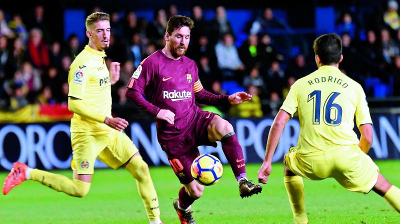 Barcelonas Messi in action against Villareal players in this file photo.