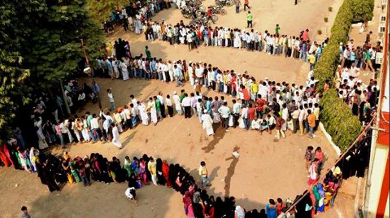 People queue up outside a bank to exchange their old Rs 500 and 1000 notes in Varanasi. (Photo: PTI)