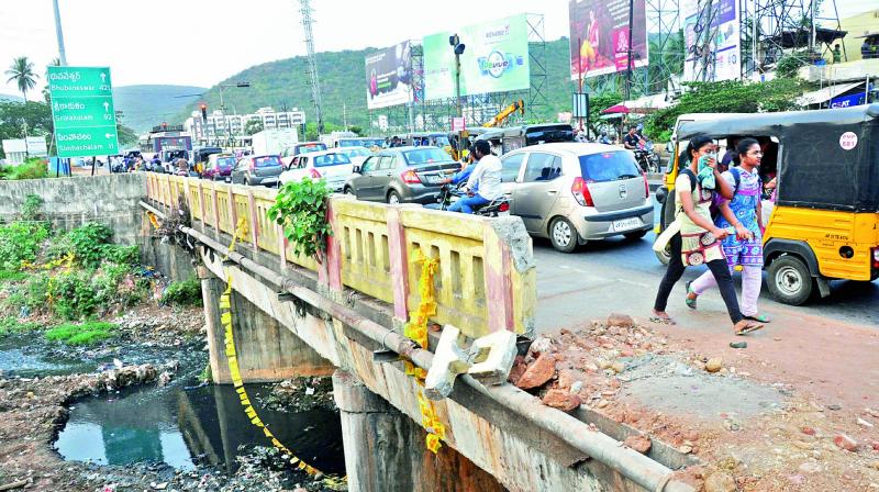 People have a tough time to move on the congested road at a culvert bridge near Hanumanthawaka in Visakhapatnam on Tuesday. (Photo: DC)