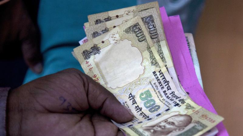 A person gives discontinued currency notes for deposit in a bank in Hyderabad. (Photo: AP)