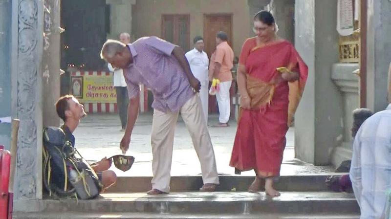 A temple visitor offers money to Evangelin Berngowe at  Kumarakottam Murugan temple in Kancheepuram. (Photo: DC)