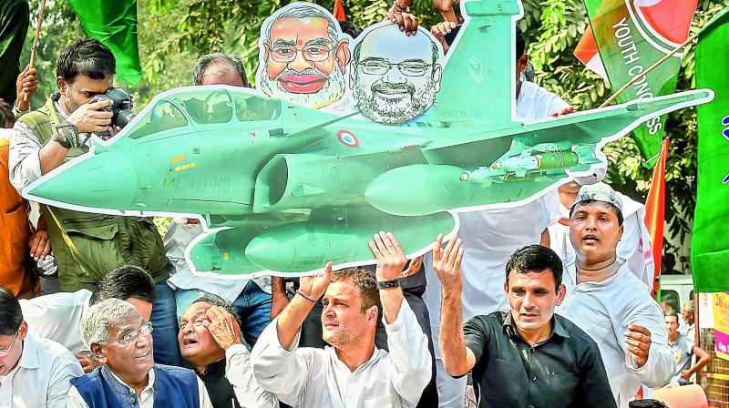 Congress president Rahul Gandhi holds a cutout of a fighter aircraft during a protest demanding the reinstatement of CBI director Alok Verma outside the CBI headquarters, in New Delhi on Friday. (Photo:PTI)