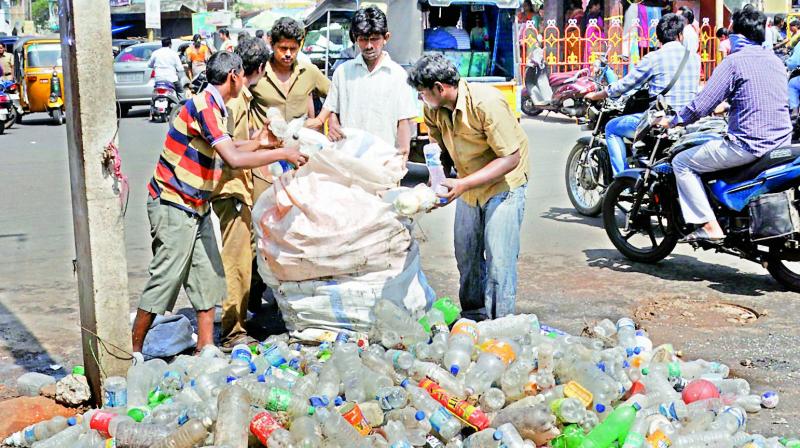 Civic staff remove plastic waste including bottles from an underground drainage line at Devi Chowk in Rajahmundry on Friday.  (DC)