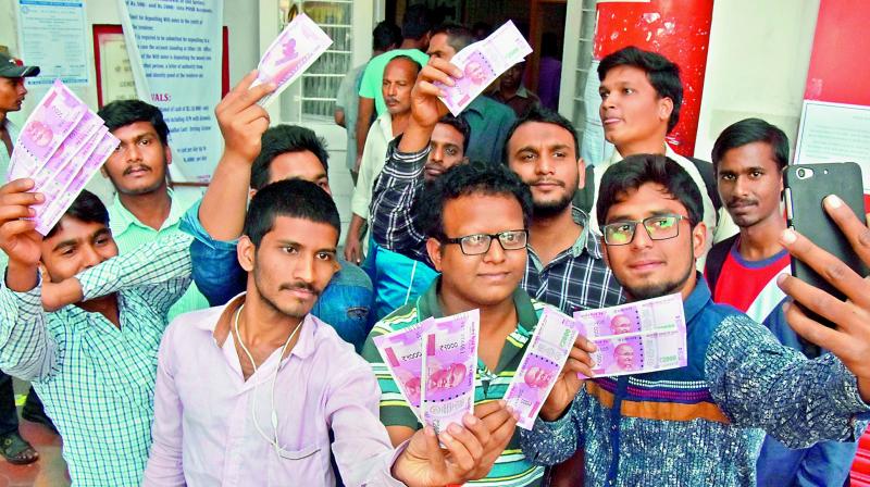 People celebrate the new 2,000 note by taking selfies and posing for pictures with it at various places in the city on Thursday. (Photo: GANDHI, R. PAVAN KUMAR)