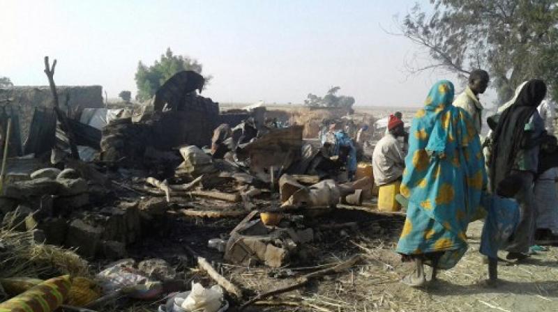 This handout image received courtesy of Doctors Without Border (MSF) shows people standing next to destruction after an air force jet accidentally bombarded a camp for those displaced by Boko Haram Islamists, in Rann, northeast Nigeria. (Photo: AFP)