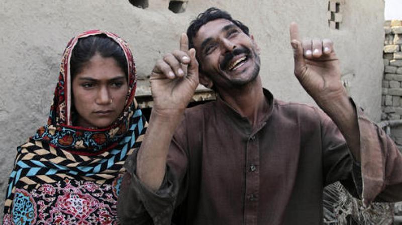Mohammad Ramzan, right, reacts while talking to his young bride Saima in Jampur, Pakistan. (Photo: AP)