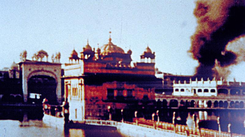 In this photograph, cloud of smoke is seen rising from an explosion behind the Manji Sahib Diwan Hall. 300 bullet holes were found in the gold panels and marble of Gurdwara Darbar Sahib after the attack. (Photo: Sikhmuseum.com)