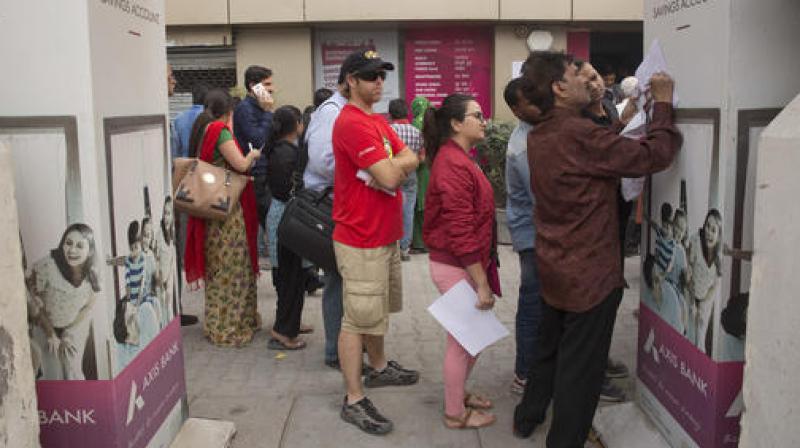 TForeign tourist stand in a queue to exchange discontinued currency notes outside a bank in New Delhi. (Photo: PTI)