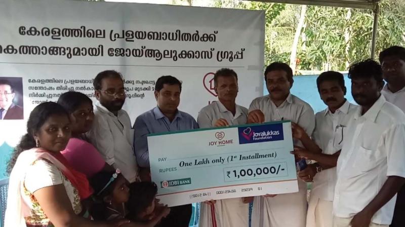 Subrahamanyan (extreme right) receives cheque of 1 lakh as first installment from  panchayat president Shivankutty Aiyilarathil (Centre) during foundation laying ceremony held at  Pandand on Friday. Joyalukkas Branch manager Jerin T. John, Subrahmanians wife Sreelekha and children are also seen.	(DC)