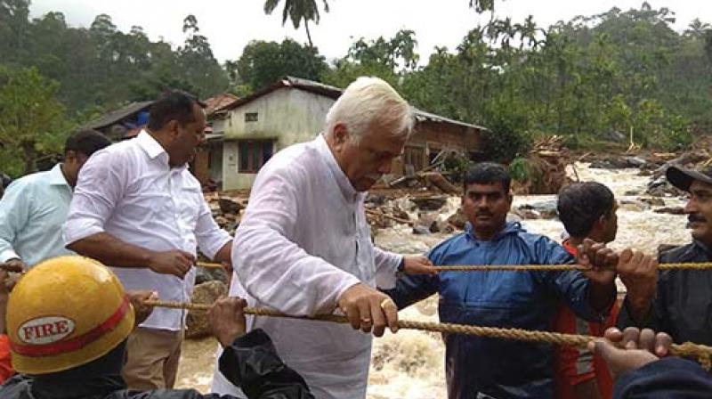 Ministers R.V. Deshpande and U.T. Khader cross a rope bridge at Jodupala on Sunday (Photo: DC)