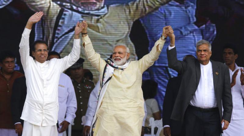 Sri Lankan President Maithripala Sirisena, left, Indian Prime Minister Narendra Modi, center, and Sri Lankan Prime Minister Ranil Wickremesinghe hold hands and wave to Sri Lankan tea plantation workers of Indian origin during a rally in Norwood, about 140 kilometers (87.5 miles) east of Colombo, Sri Lanka, Friday, May 12, 2017. (Photo: AP)