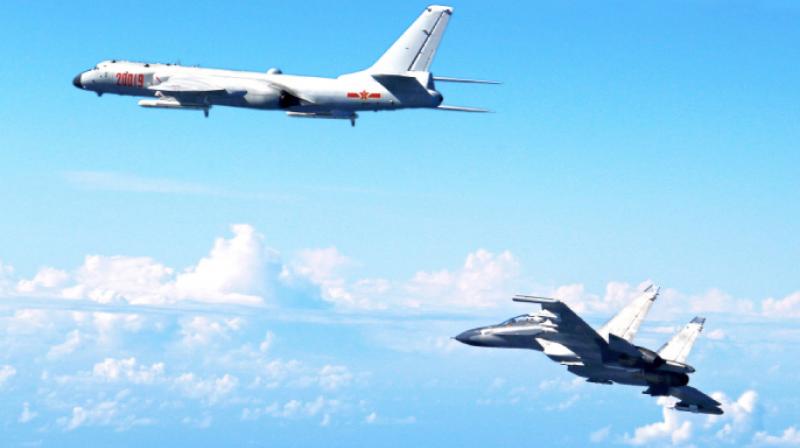 Chinese Peoples Liberation Army Air Force Su-30 fighter, right, flies along with a H-6K bomber as they take part in a drill near the East China Sea. (Photo A