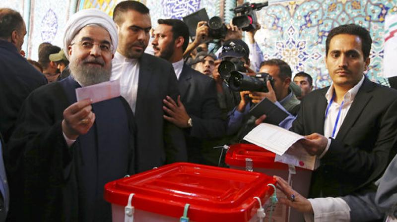 President Hassan Rouhani holds his ballot while voting for the presidential and municipal councils election at a polling station in Tehran, Iran. (Photo: AP)