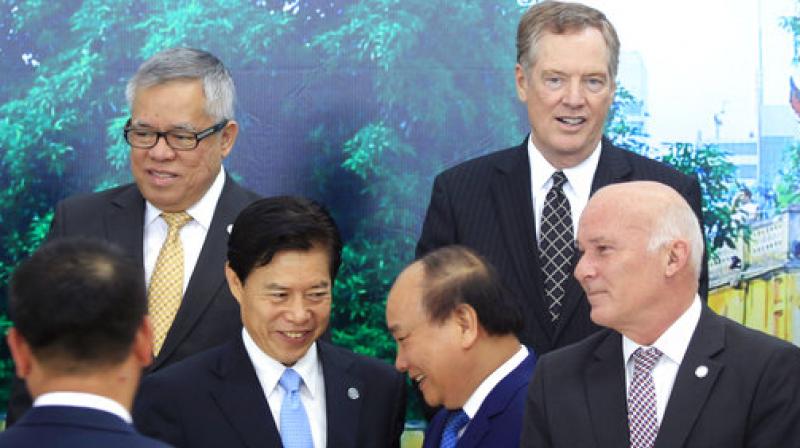 Vietnamese Prime Minister Nguyen Xuan Phuc, center right, shakes hands with Chinese Minister of Commerce Zhong Shan, center left, as Philippine Trade Secretary Ramon Lopez, top left, U.S Trade Representative Robert Lighthizer, top right, and Peruvian Trade Minister Eduardo Ferreyros, bottom right, look on after a group photo at the Asia-Pacific Economic Cooperation (APEC) Trade ministerial meeting in Hanoi, Vietnam. (Photo: AP)